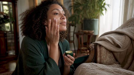 Woman applying multi-use balm in bathroom