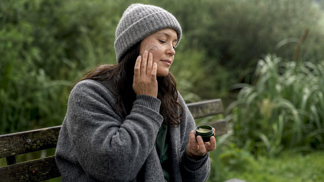 Woman applying tallow balm on cheek outdoors